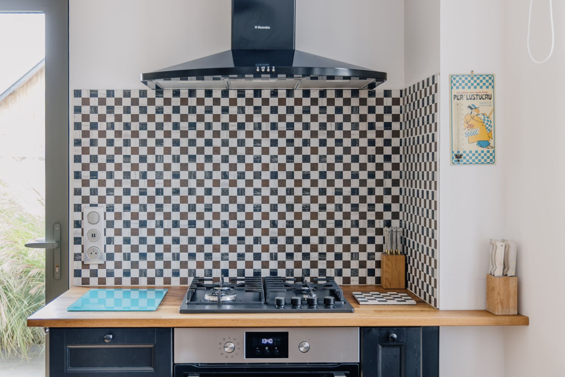 Le piano de cuisson et la faïence à damier de la cuisine