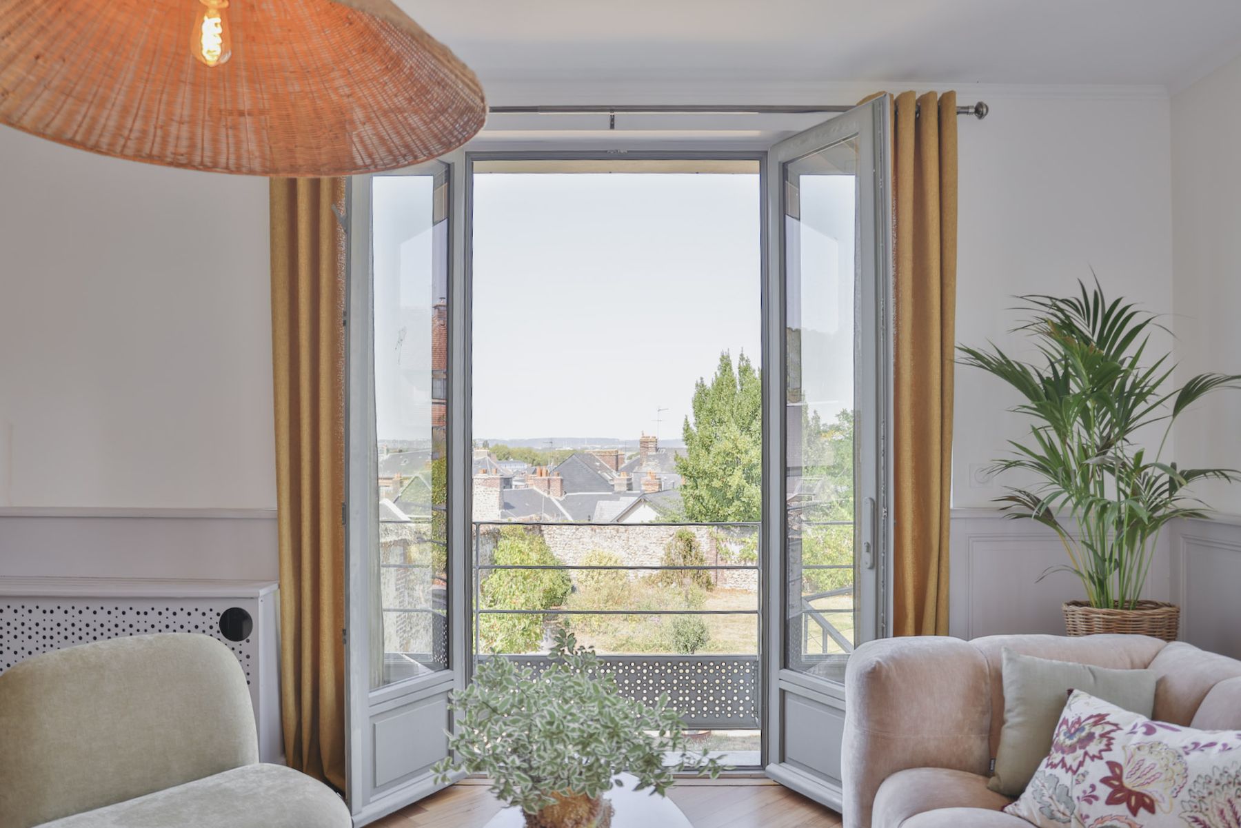 La porte-fenêtre du salon ouverte sur les toits de Honfleur