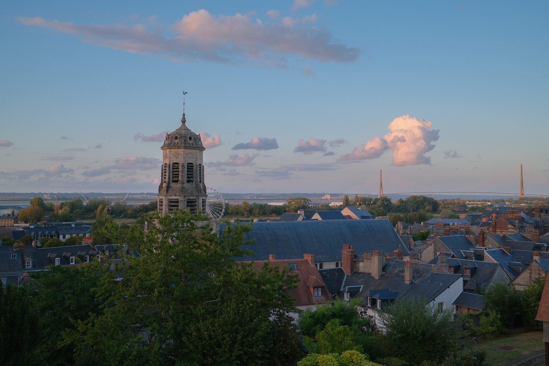 The Saint-Léonard bell tower and the Pont de Normandie at sunset